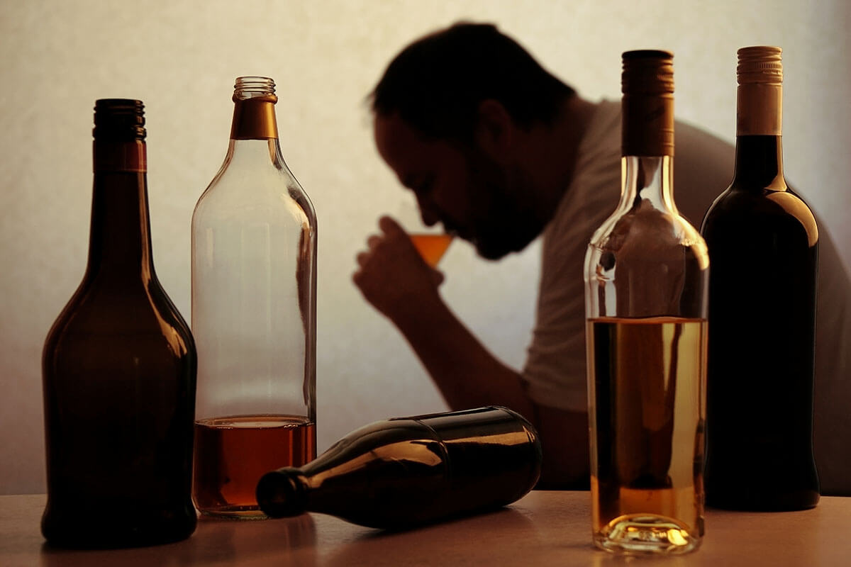 man drinking with a bunch of bottles, how much alcohol is too much