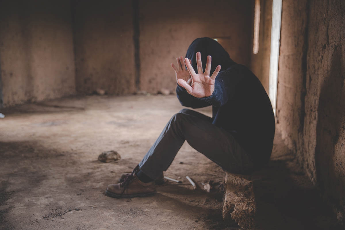 man in hoodie in abandoned building hiding his face, how to quit heroin