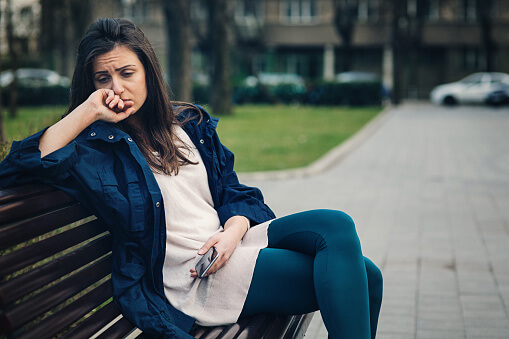 woman on park bench has a drug addiction