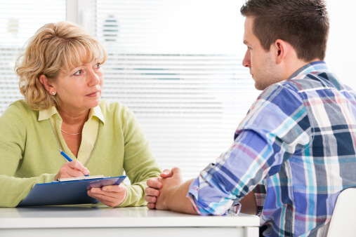 A counselor discusses family therapy with a patient.