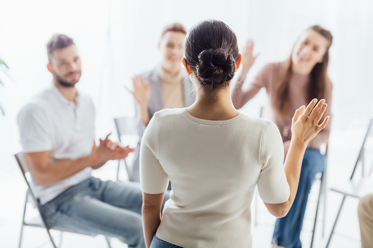 woman standing up to speak to group at a rehab center near austin