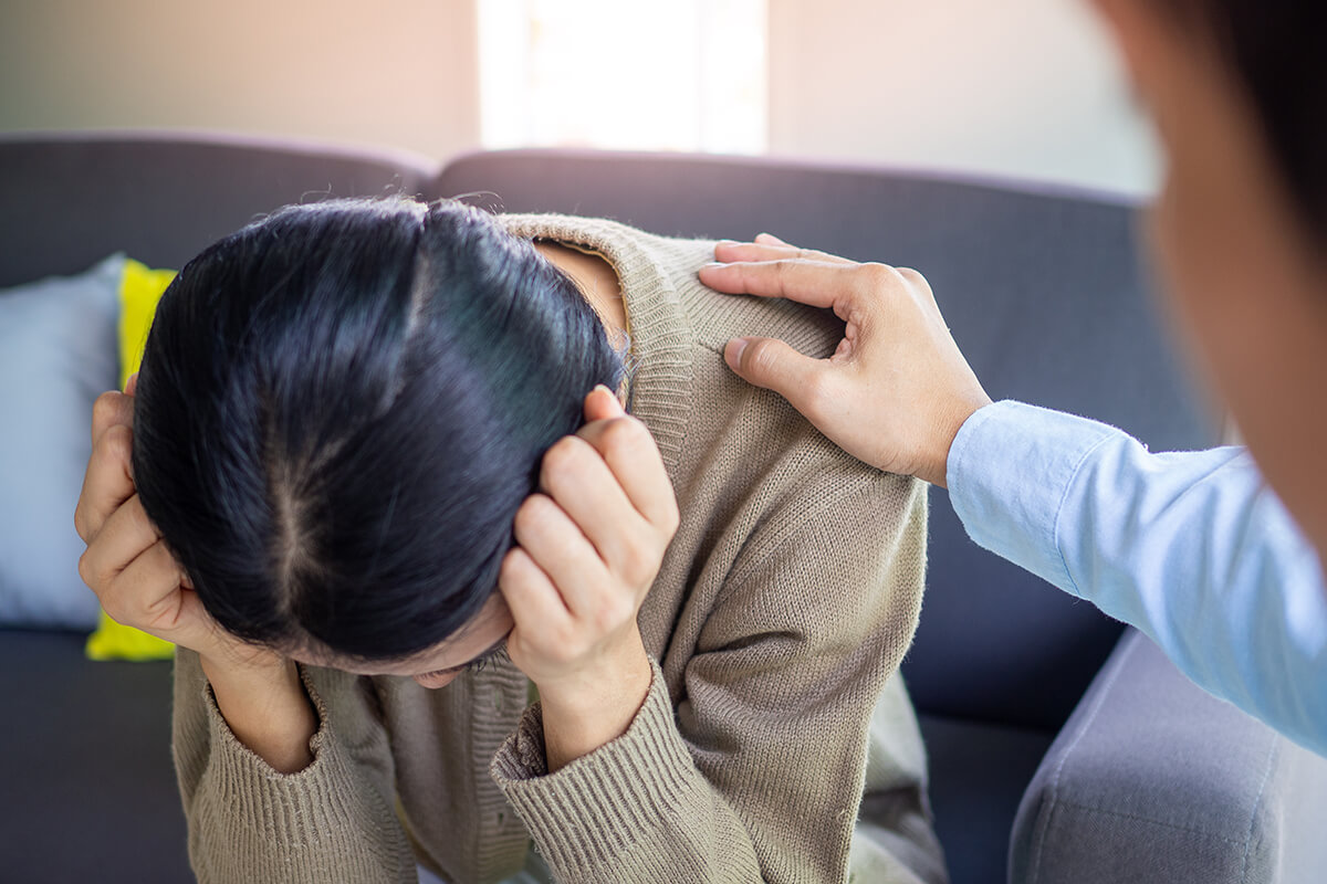 woman leaning over holding her head needing rehab near austin