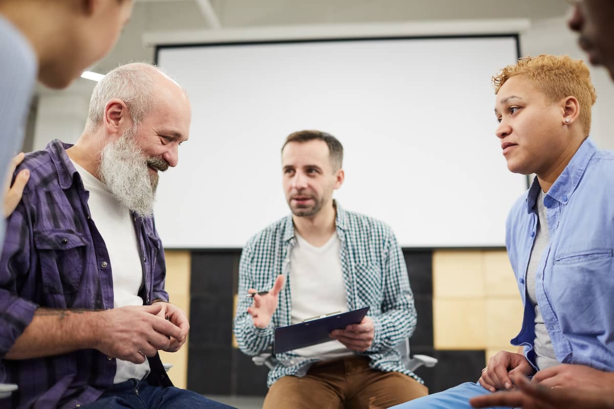 a group of men participate in group therapy