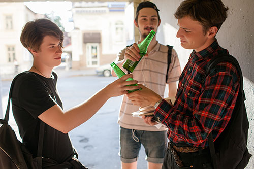 three teenagers participating in underage drinking