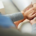 two individuals holding hands during an Addiction Counseling program