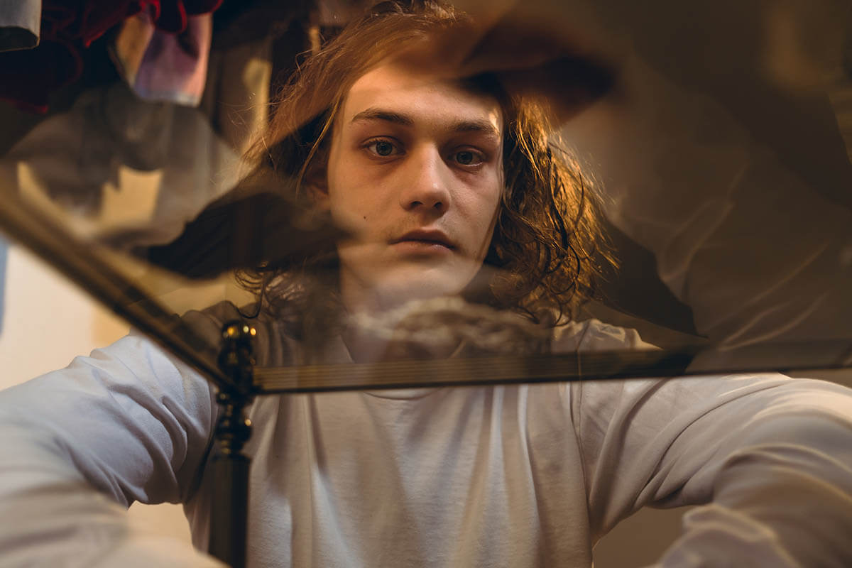 deadeyed teen looking through a glass table suffering from teen drug abuse