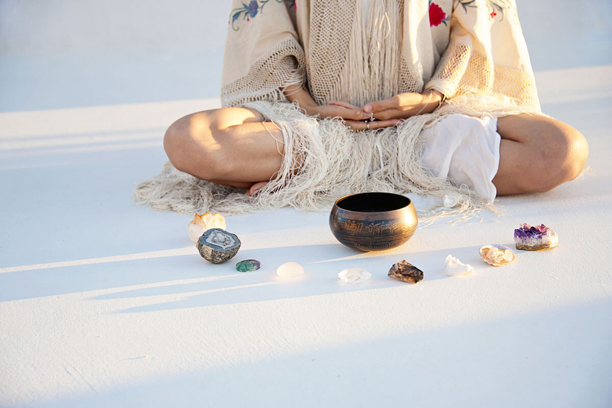 person sitting crosslegged with crystals during holistic treatment