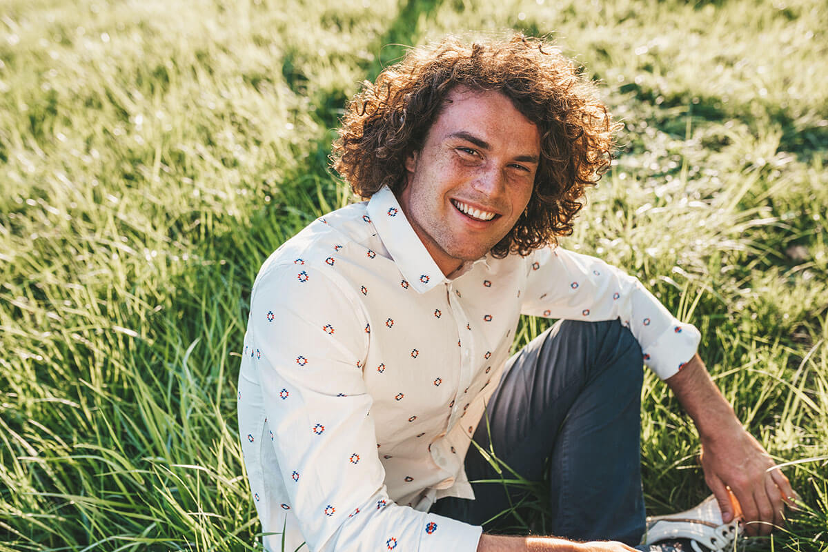 man sitting smiling on field outside our San Antonio detox center for drugs and alcohol