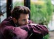 A man pondering the question, "How does alcohol affect the brain?"