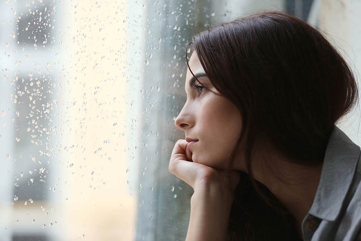 woman looking out window thinking about effects of heroin