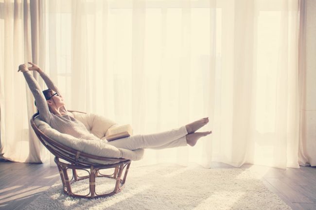 woman stretching in papasan chair ready for national recovery month