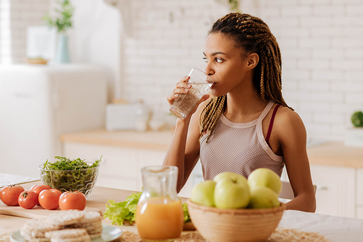A woman drinking water and understanding the link between nutrition and mental health