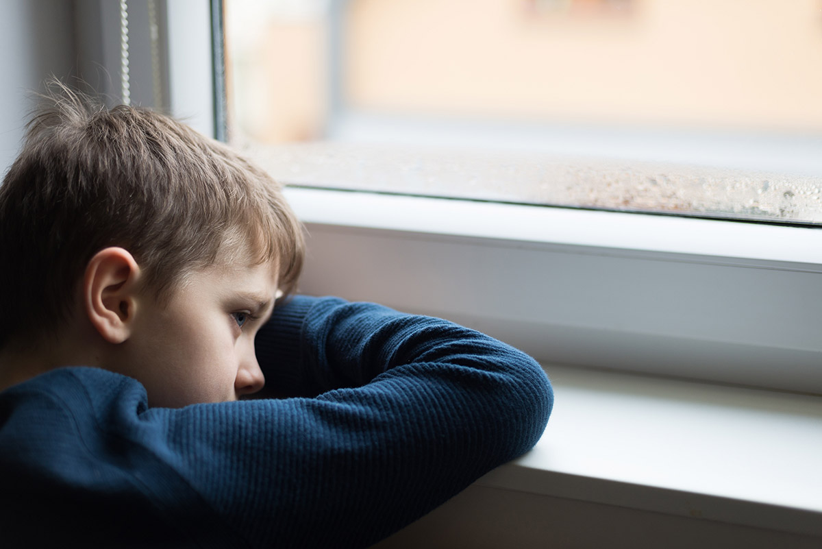 child at window dealing with childhood trauma and addiction