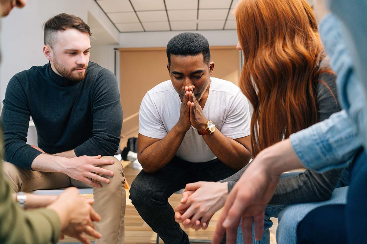 A group of people discuss challenges in sobriety during recovery