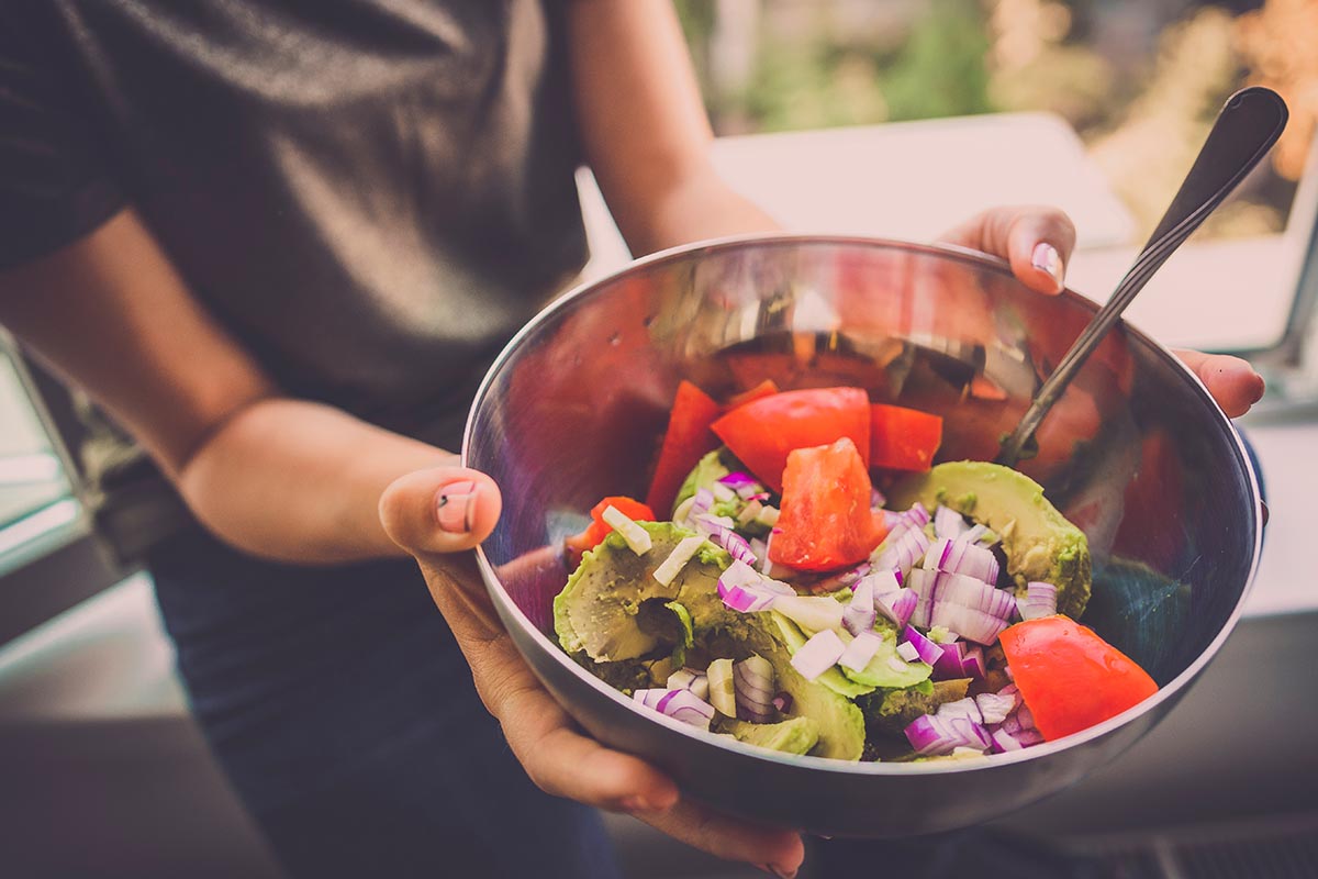 Woman holding food bowl and realizing the connection between diet and addiction recovery