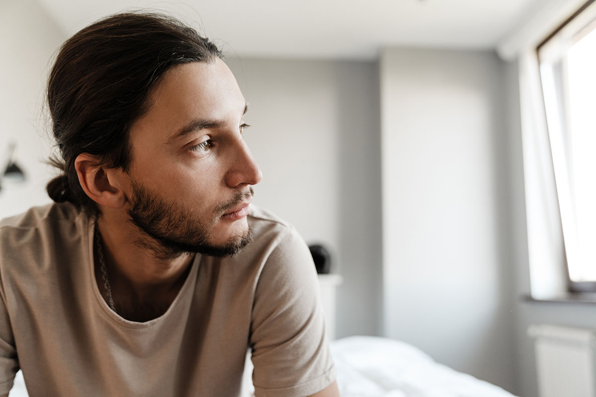 Man pondering the question, "Is alcohol a depressant?"