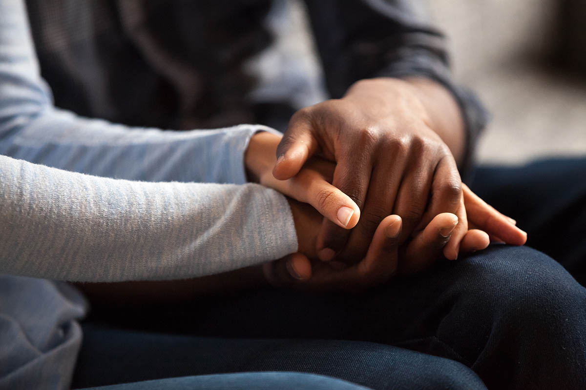 Two people holding hands, symbolizing coping with your loved one in addiction treatment
